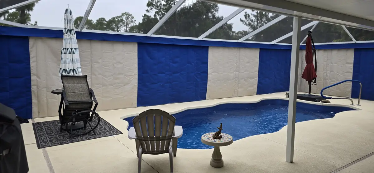 Blue and cream Sunbrella curtains surrounding Fort Myers pool enclosure
